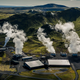 An aerial view of the Hellisheidi Geothermal Park in Iceland with steam billowing up.